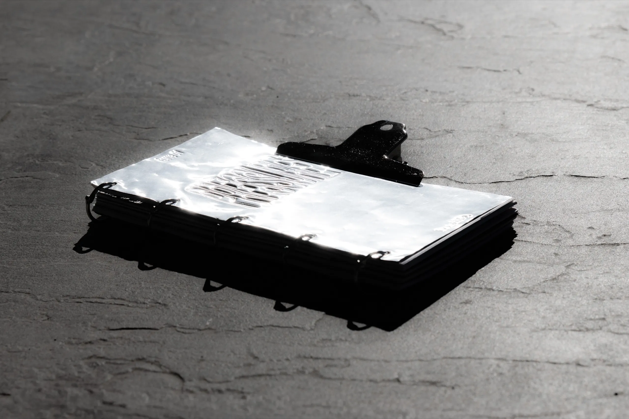 Hostilia closed with a black clip, its metal cover reflecting the light