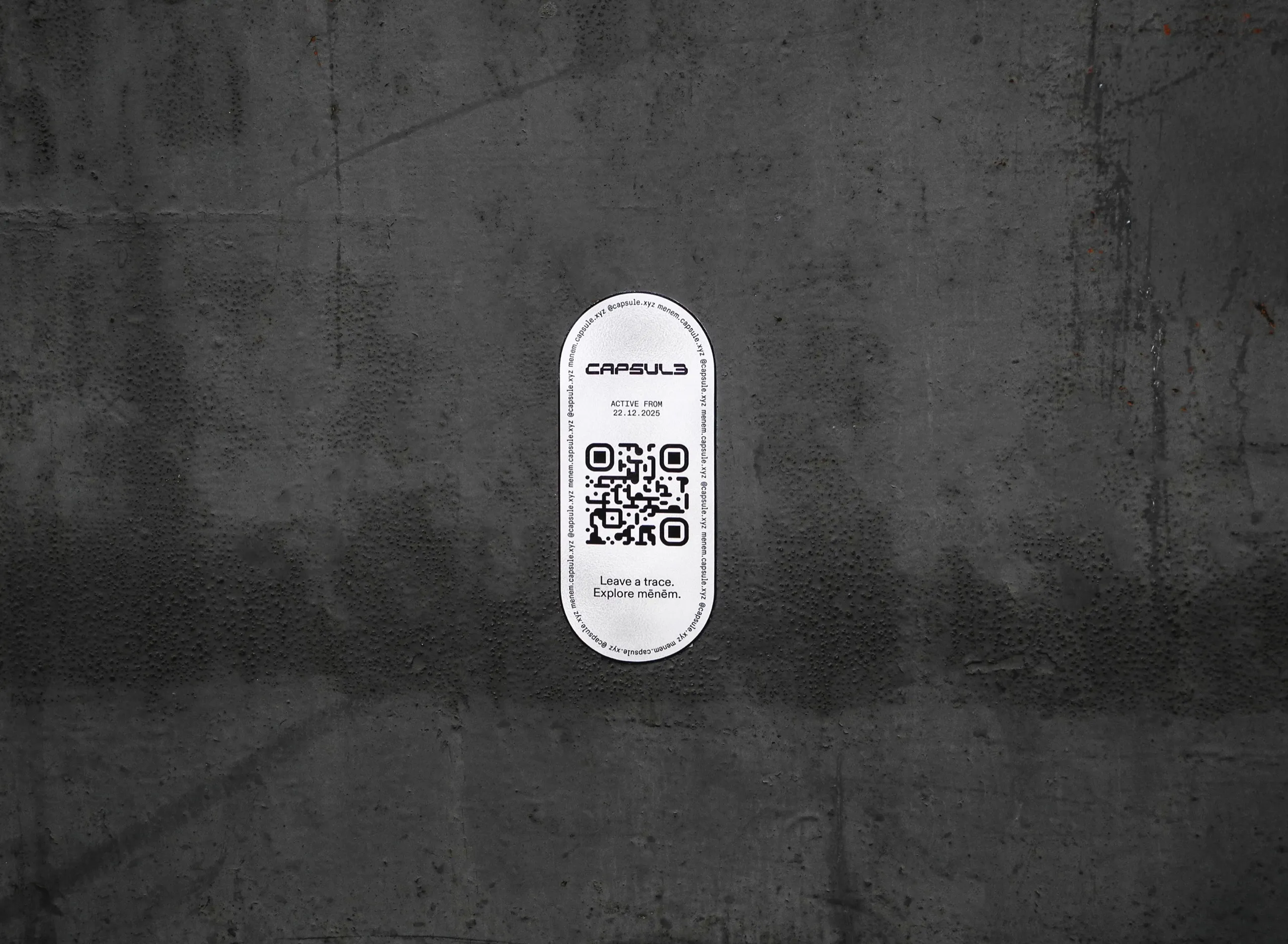 A Capsule sticker with a QR code on a concrete wall